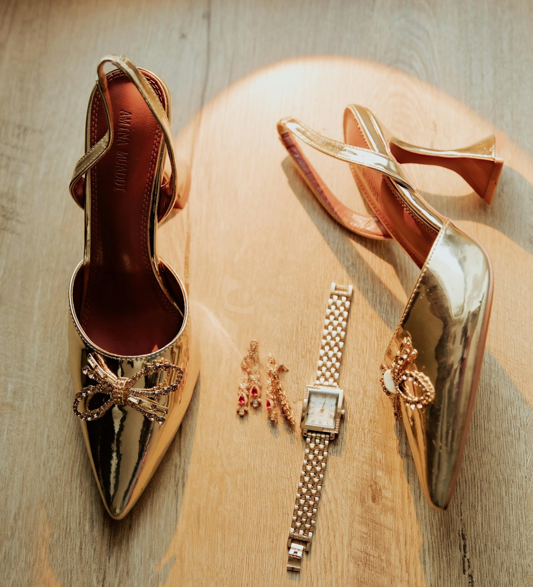 Curated fashion accessories including gold jewelry and black leather handbag